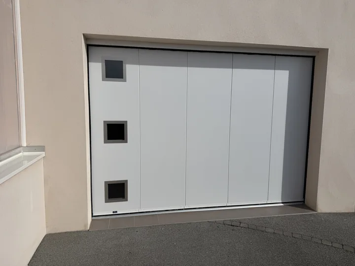 Porte de garage à déplacement latéral et hublots — vue 1